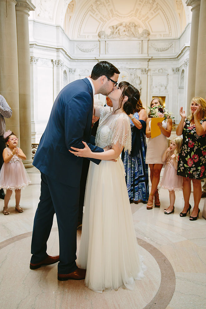 San Francisco wedding
photographer, groom kisses his bride during their San Francisco City Hall wedding ceremony in the Rotunda