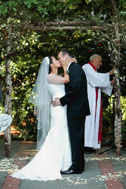 Bride and groom share kiss during their wedding ceremony at the Outdoor Art Club in Mill Valley