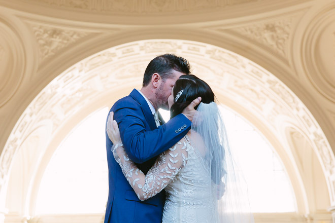San Francisco wedding
photographer, bride and groom kissing during their wedding ceremony at San Francisco City Hall